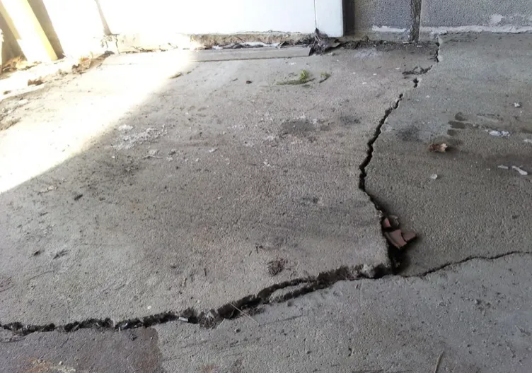 Cracked and settled garage floor slab before replacement in Island Lake IL