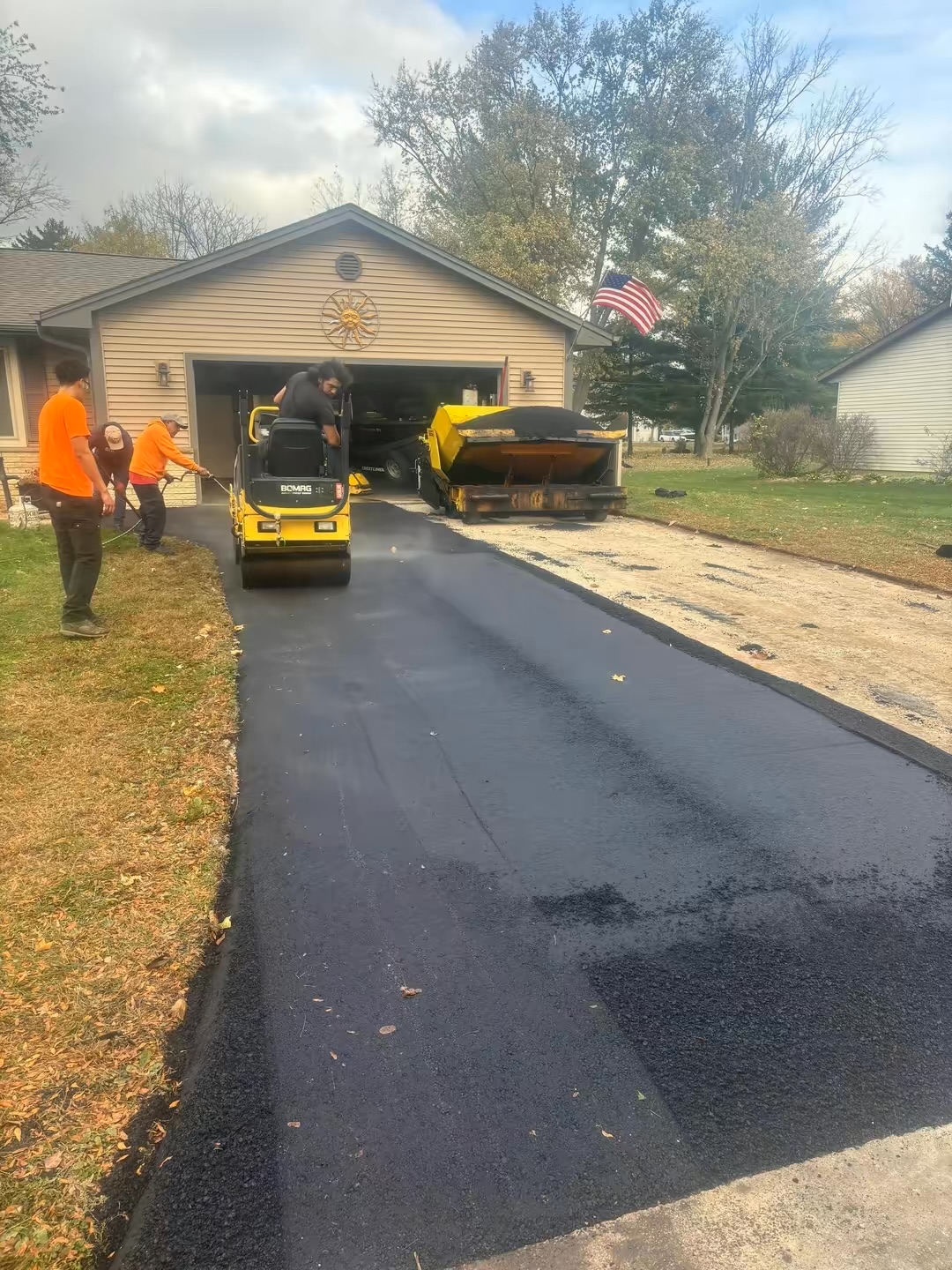 Asphalt driveway being paved with roller compactor in McHenry County IL
