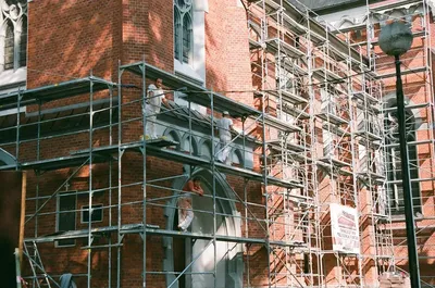 RCC crew on scaffolding performing brick restoration on a historic building