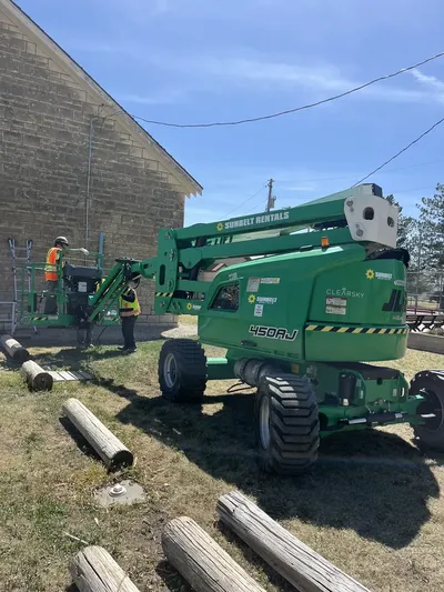 RCC crew with Sunbelt Rentals boom lift at large stone block building