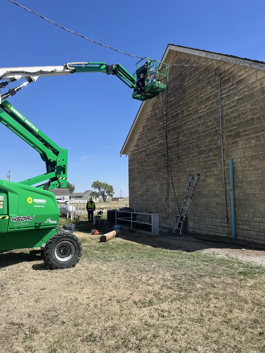 RCC technician on extended boom lift performing high-elevation masonry repair